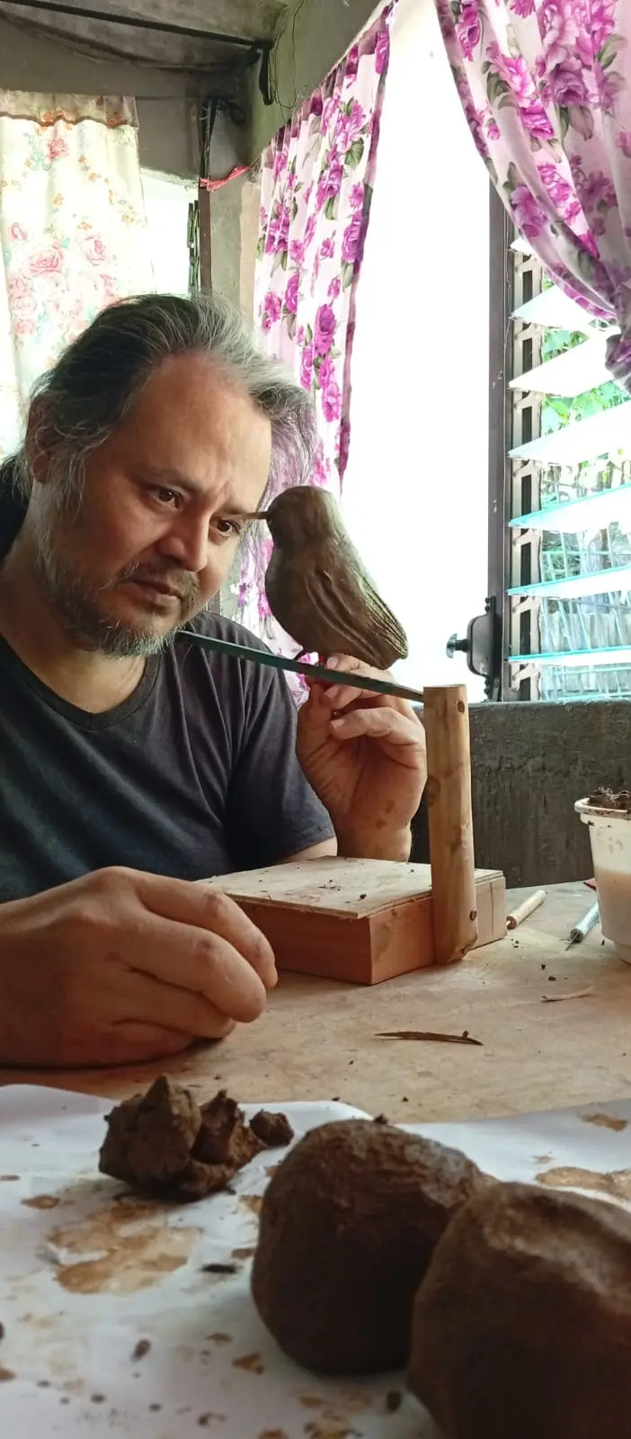 Artesano modela y pinta una figura de ave