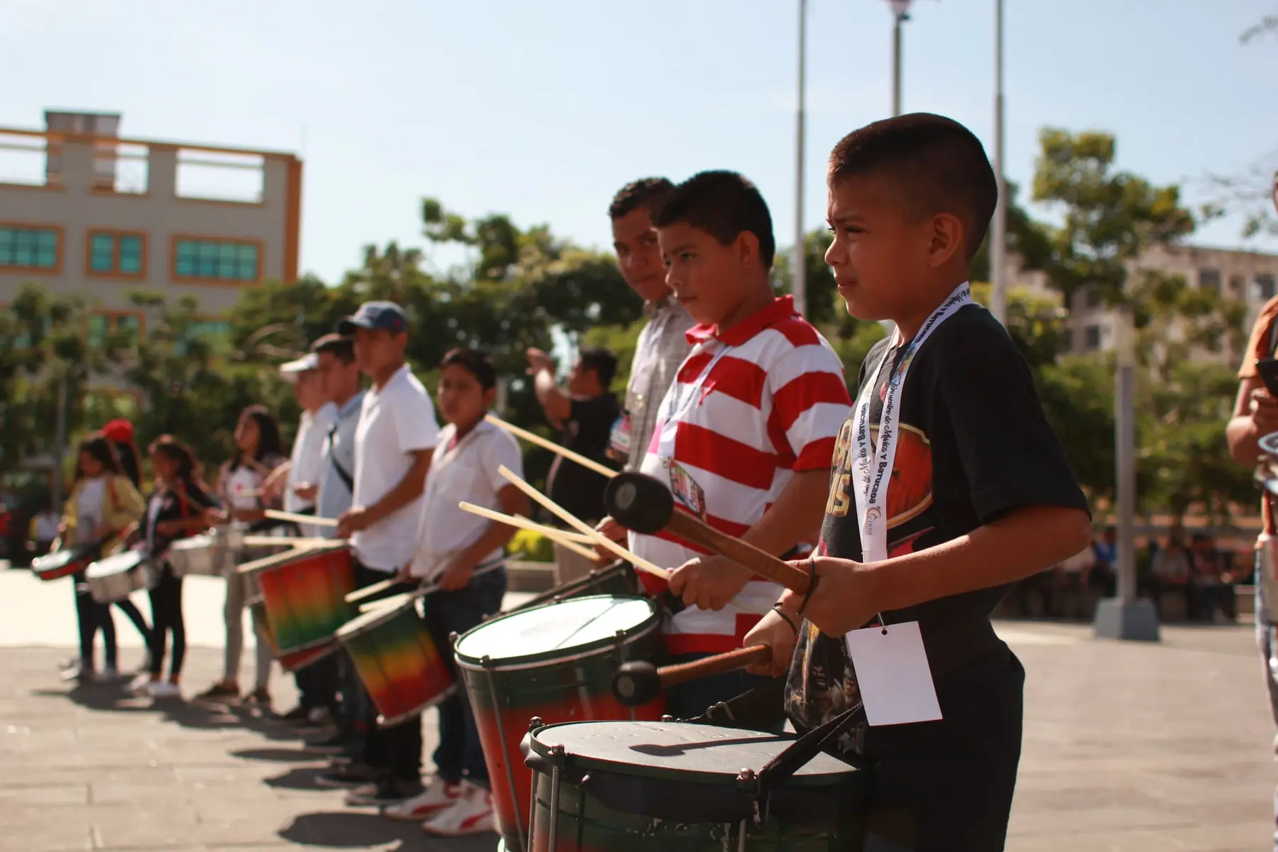 Estudiantes interpretan percusión en un espacio abierto
