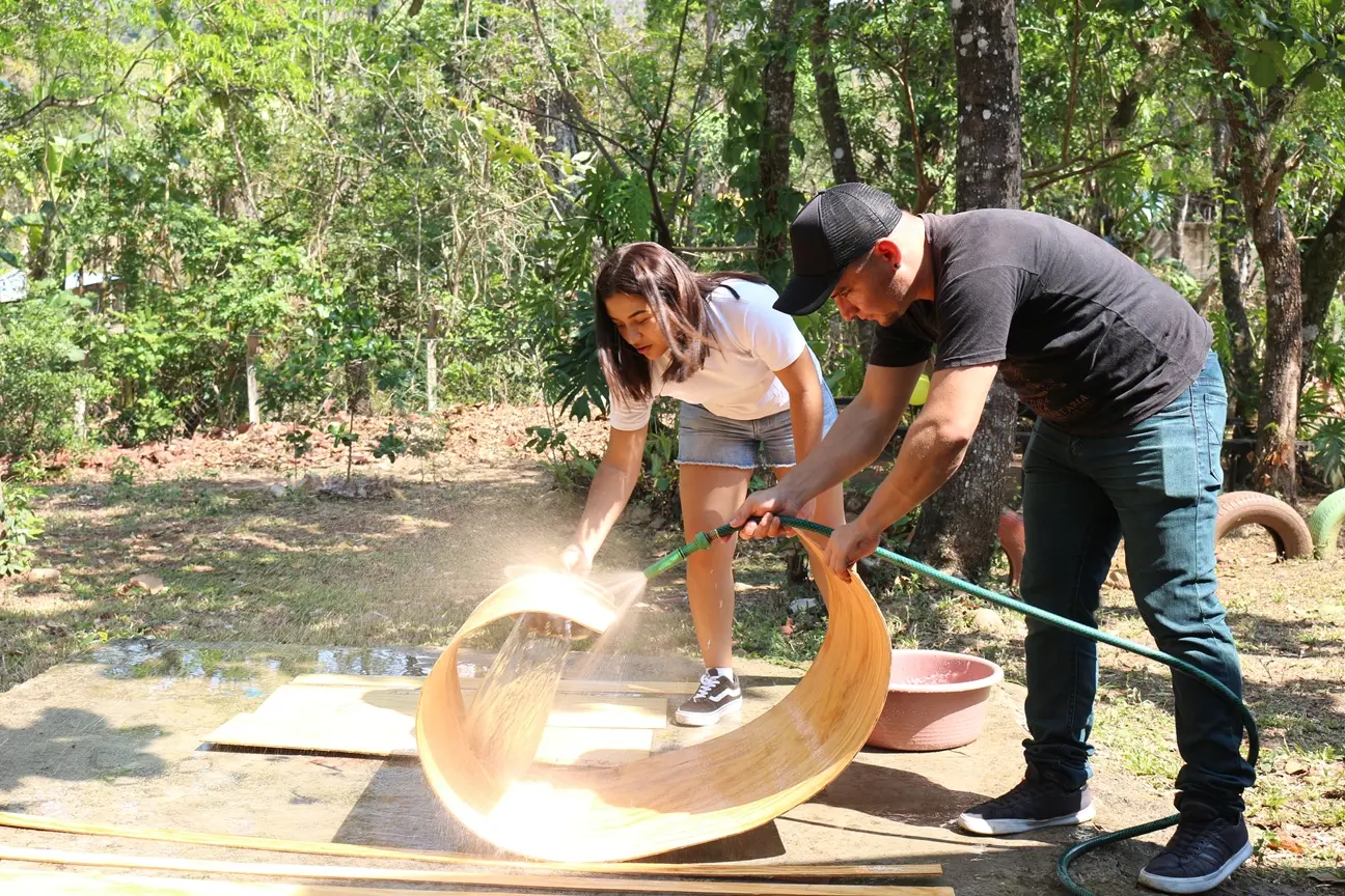 Participantes acondicionan madera para construir un tambor